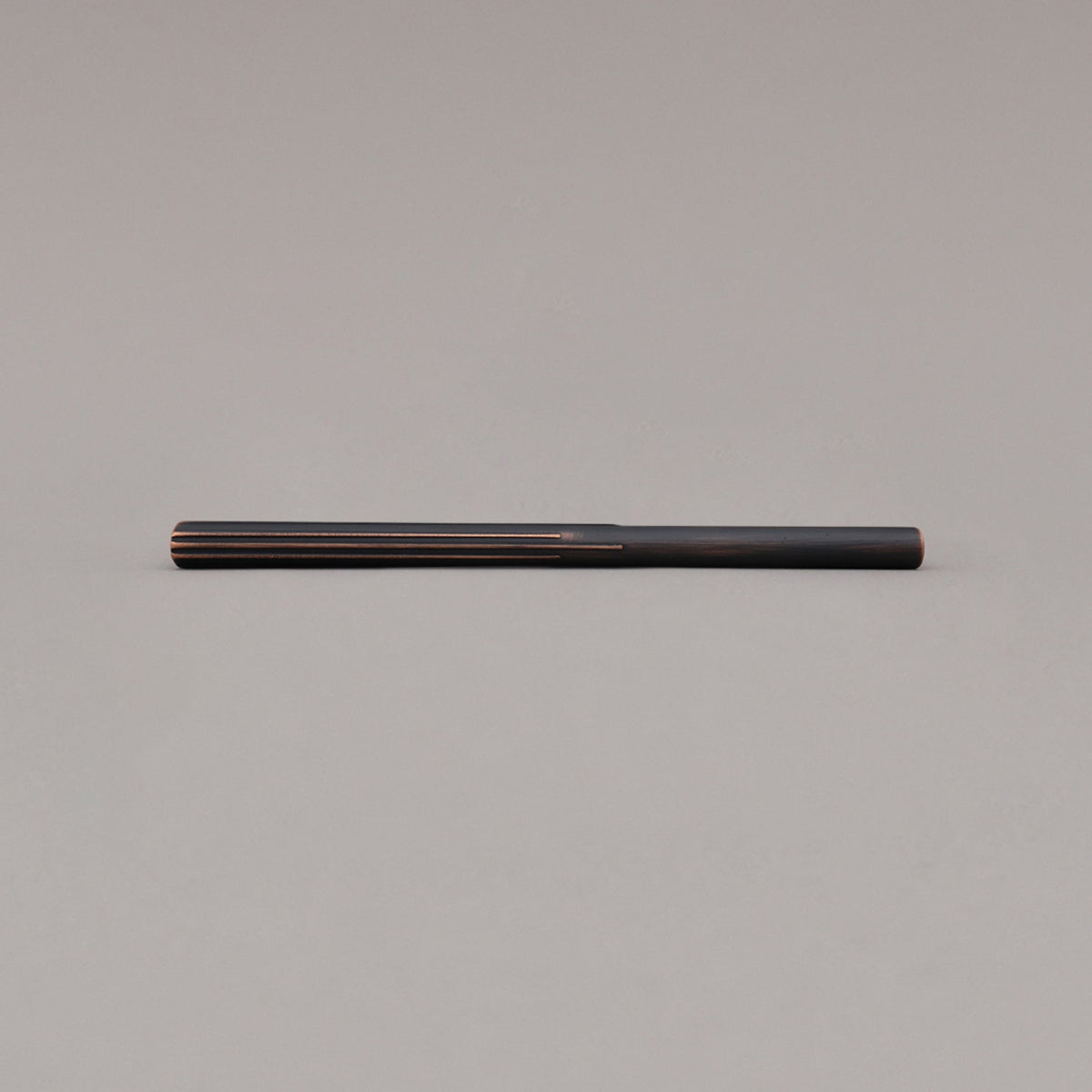 large venetian bronze sunburst pull laying on gray background