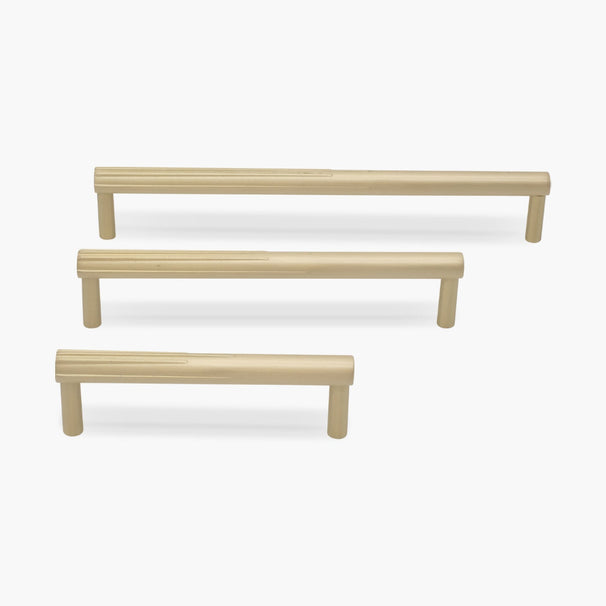 three satin brass gold sunburst cabinet pulls in three different sizes on white background