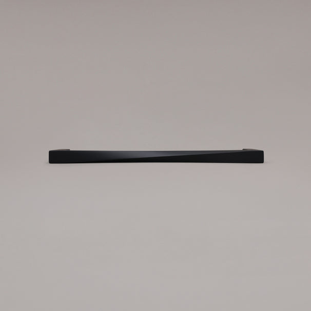 12" Twist appliance pull in Matte Black laying on gray background