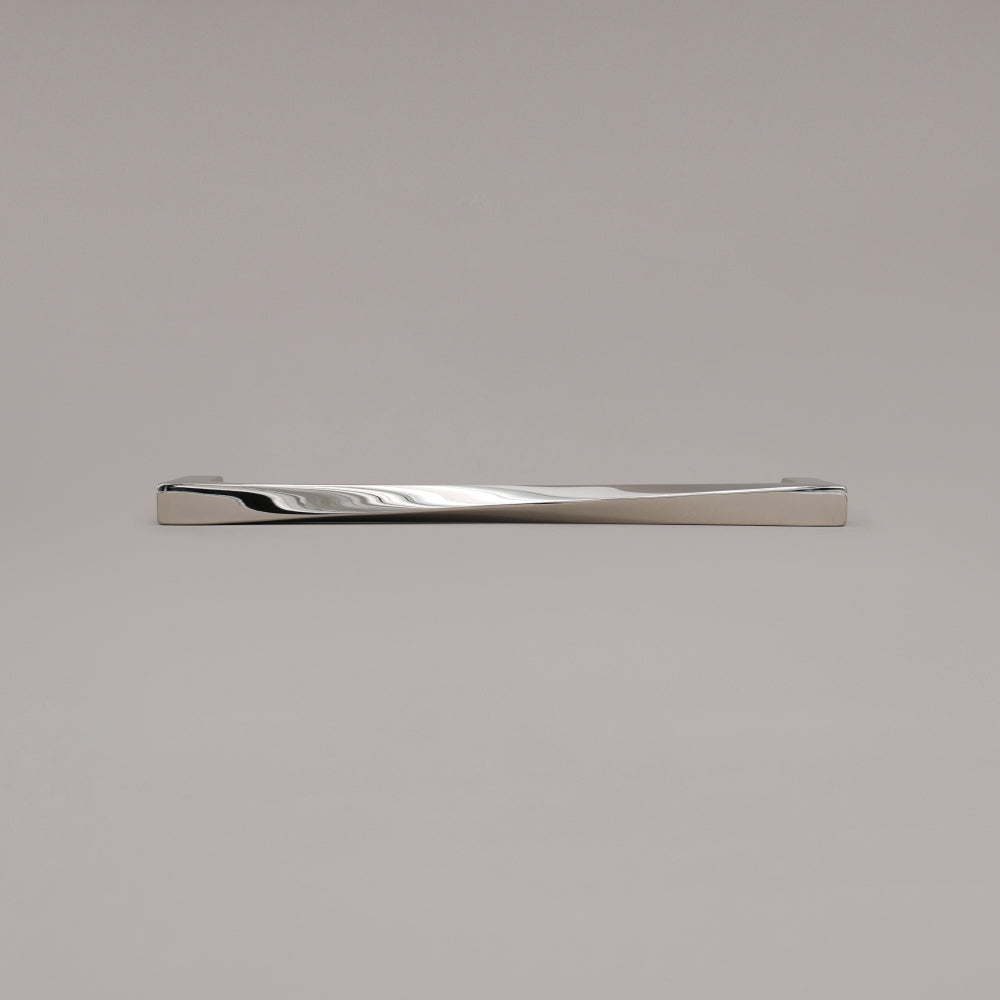 12" Twist appliance pull in Polished Nickel laying on gray background