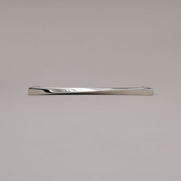 12" Twist appliance pull in Polished Nickel laying on gray background