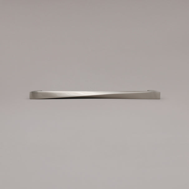 12" Twist appliance pull in Satin Nickel laying on gray background