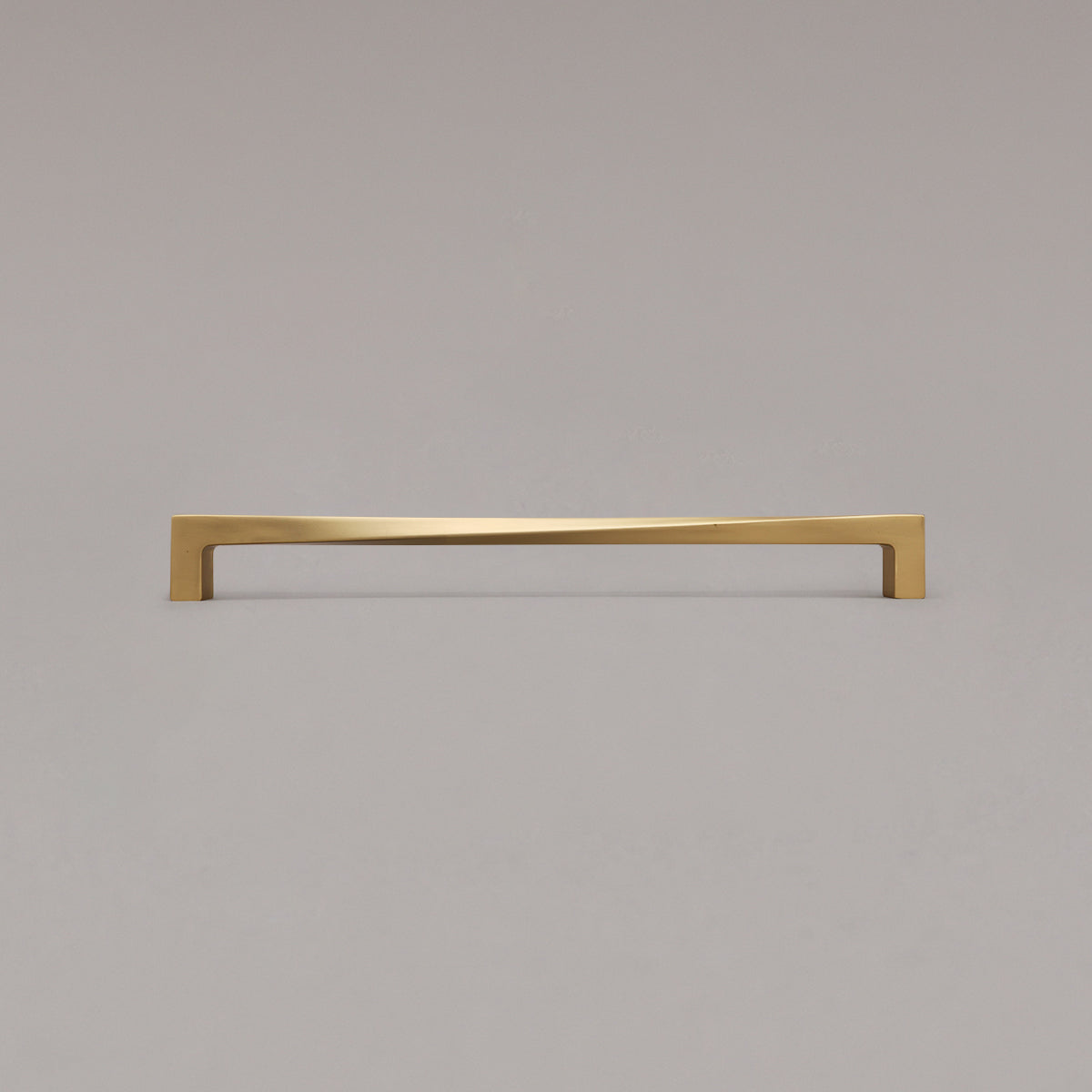 18" twist appliance pull in satin brass standing on gray background