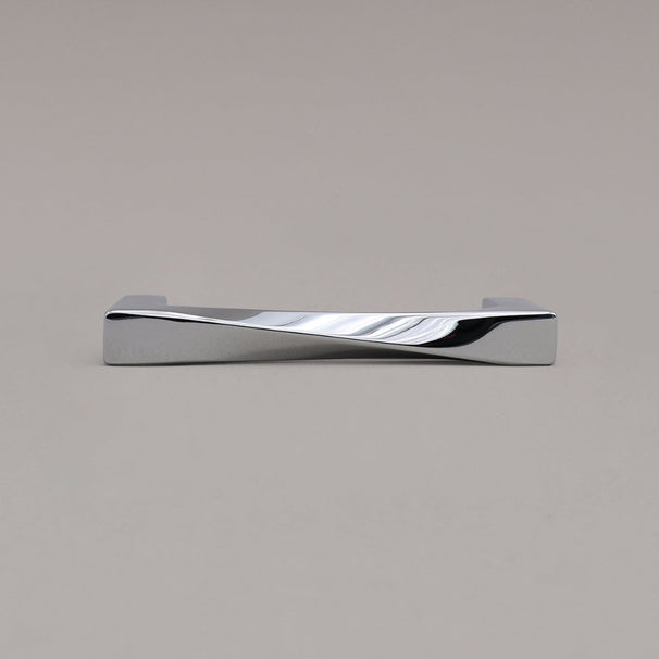 small polished chrome twist cabinet pull laying down on gray background