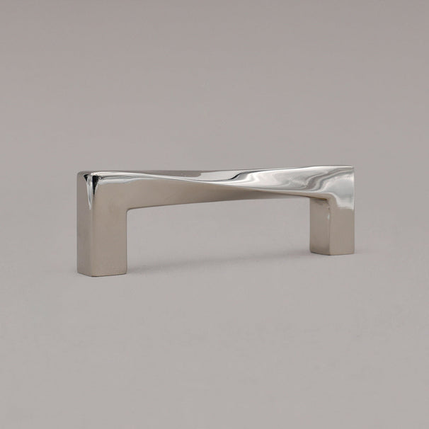small twist polished nickel pull standing on gray background, angled