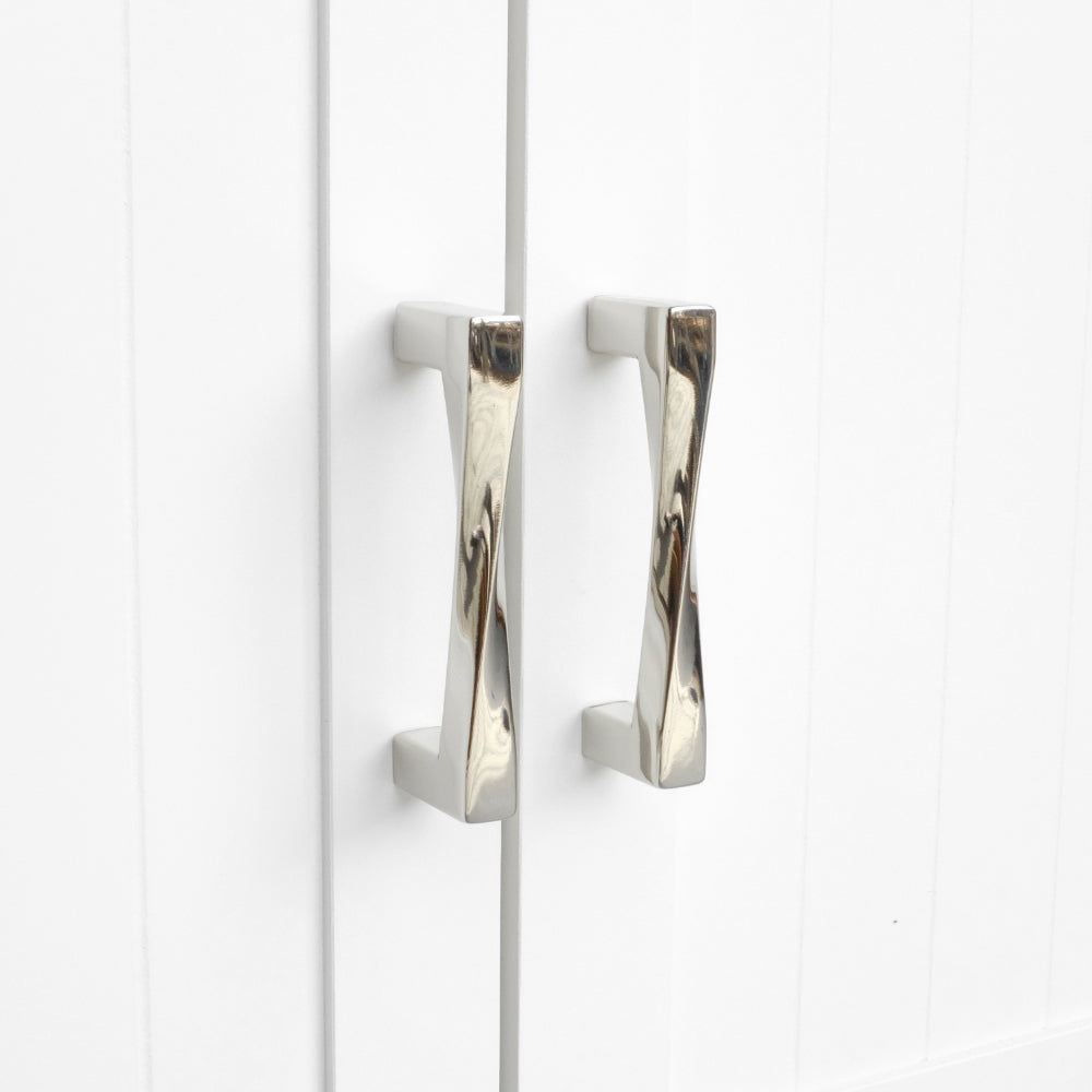 polished nickel cabinet pulls installed on white cabinet