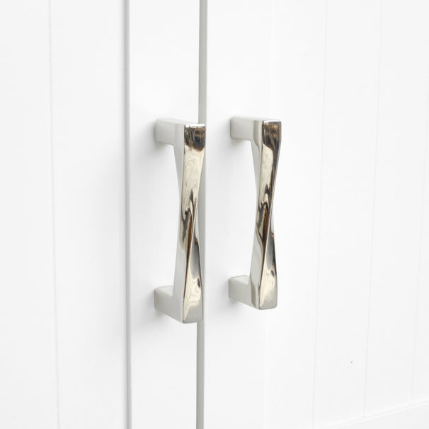 polished nickel cabinet pulls installed on white cabinet