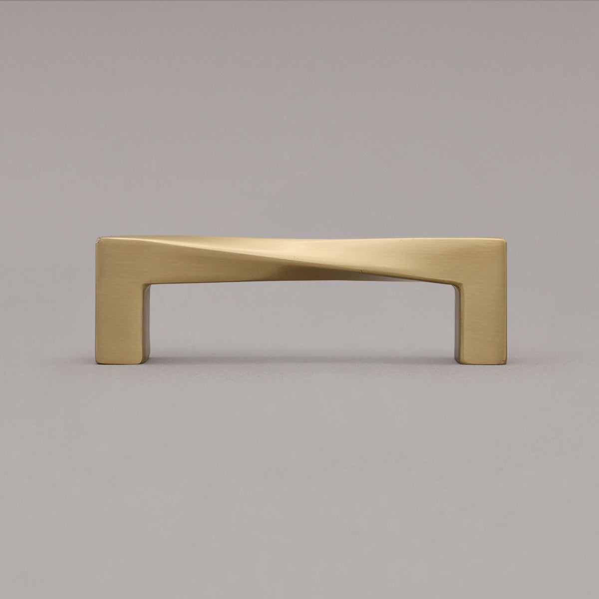 Small satin brass gold twist pull standing on gray background