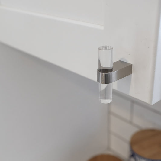 Acrylic cabinet knob in black finish on dark kitchen cabinets.