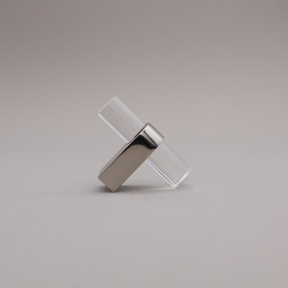 Polished nickel and acrylic knob against a gray background