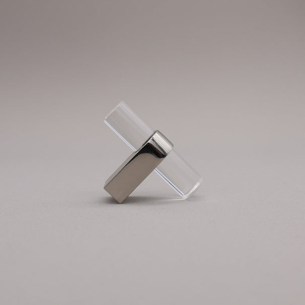 Polished nickel and acrylic knob against a gray background