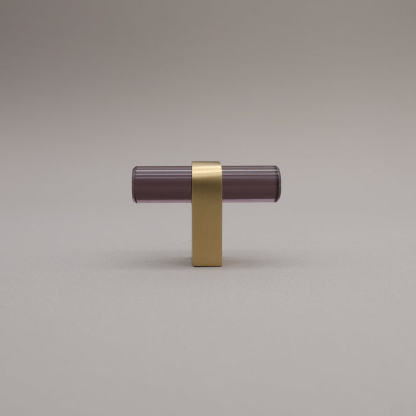 Smoke acrylic and satin brass stem knob on gray background