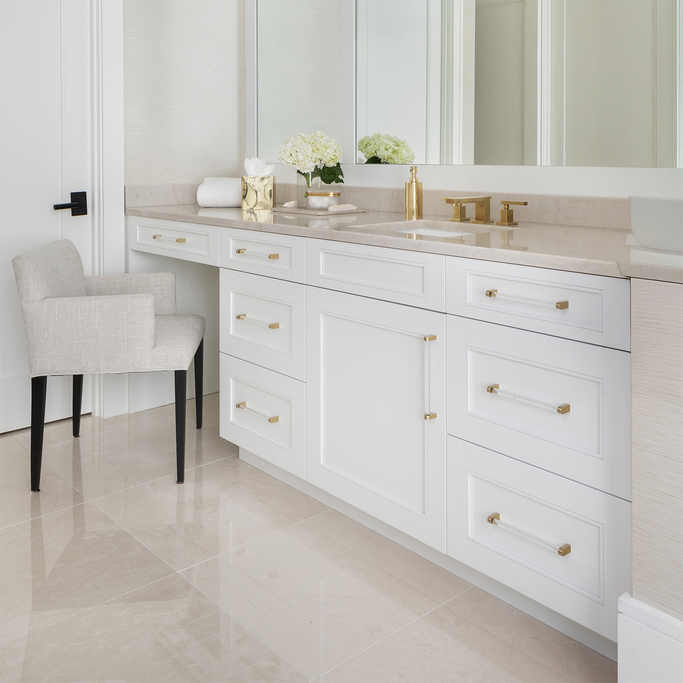 Acrylic and Gold Bathroom Hardware on white cabinets in a bathroom.