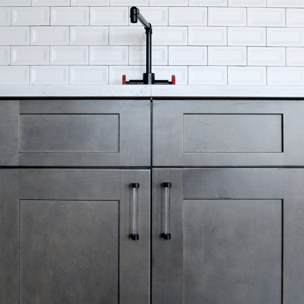 clear and matte black pulls on gray cabinets