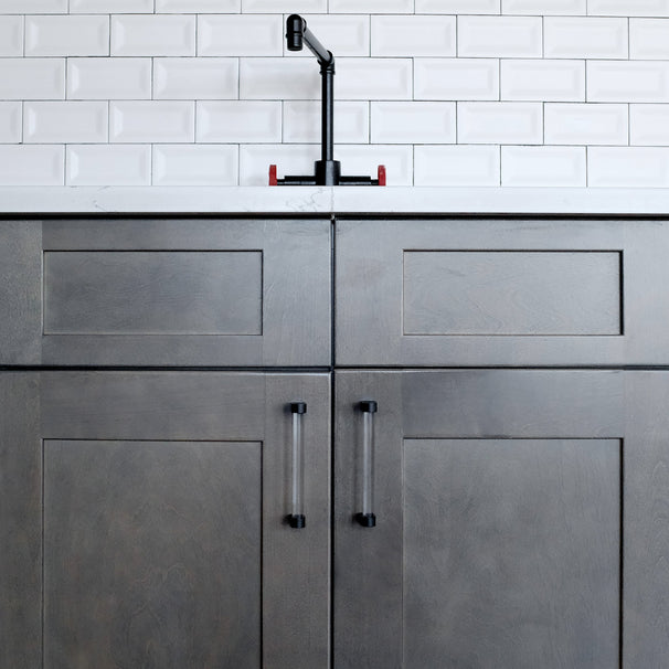 clear and matte black pulls on gray cabinets