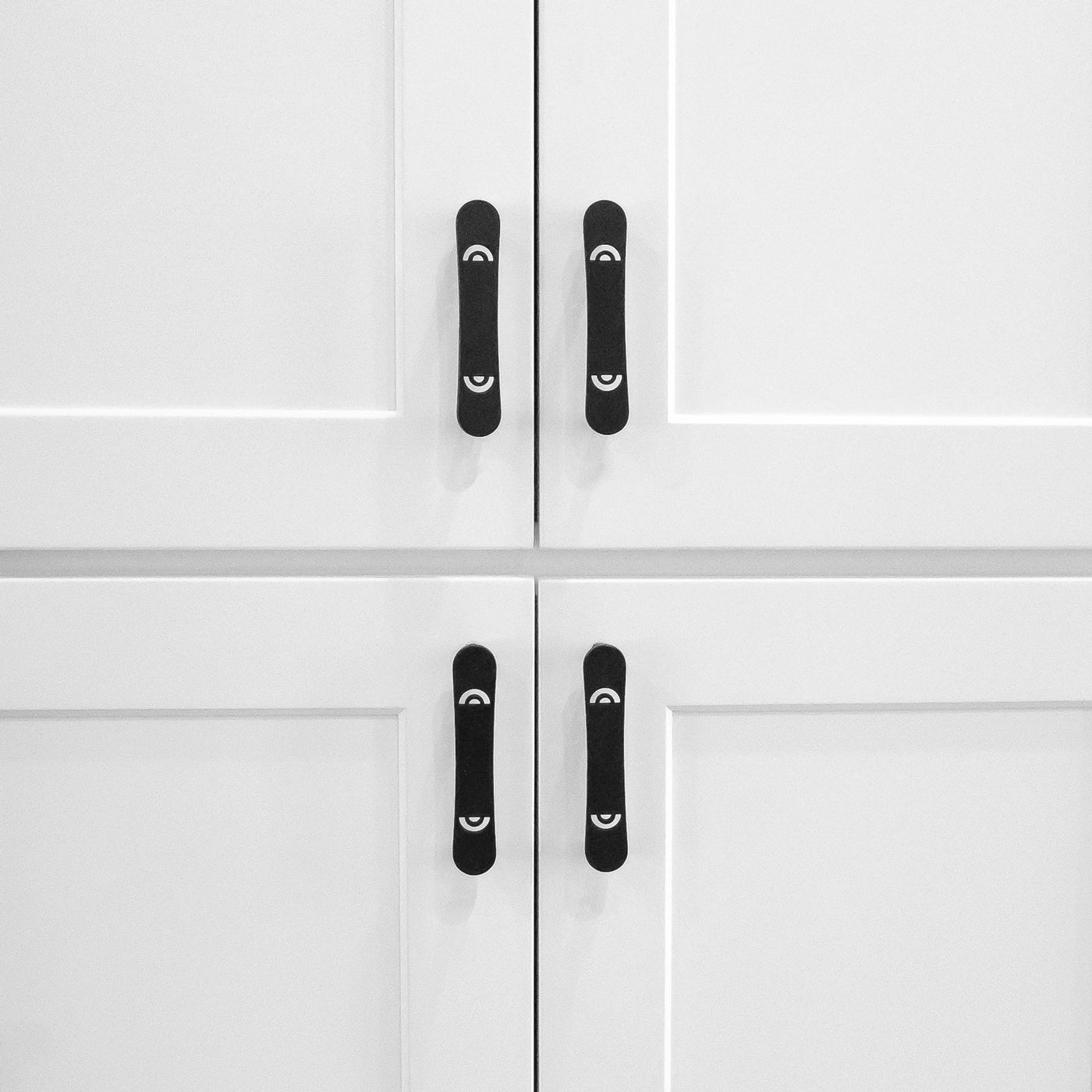 Luxury black cabinet pulls in matte black in a kitchen on white cabinets.