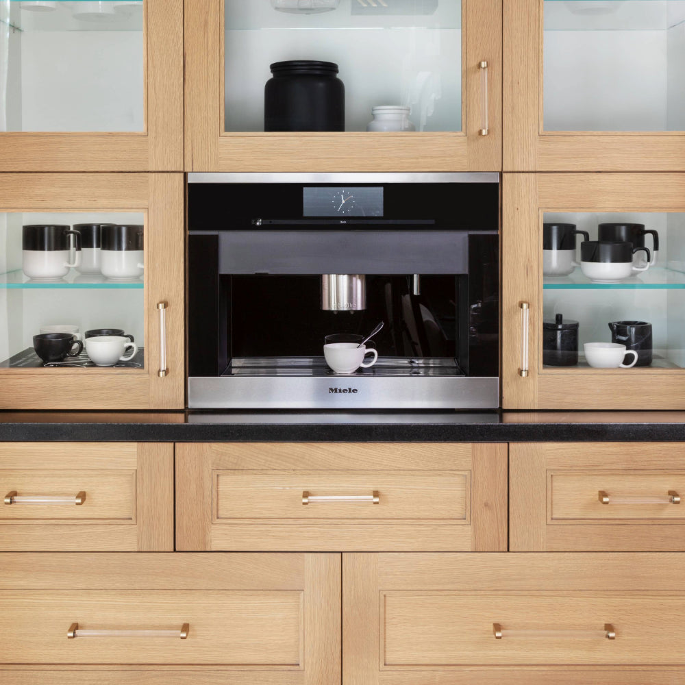 clarity satin brass cabinet pulls installed on wooden kitchen cabinets