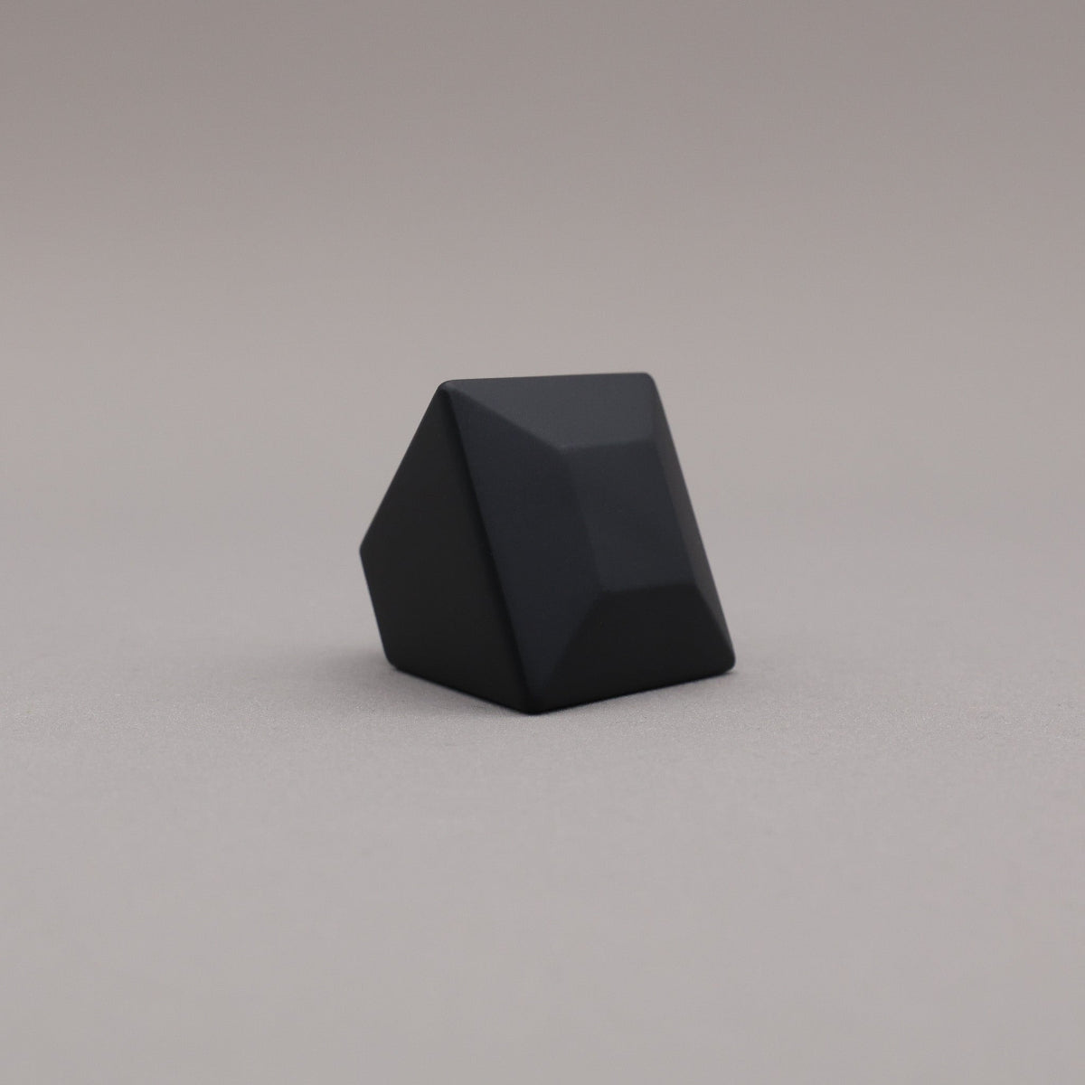 matte black geometric diamond knob on a gray background