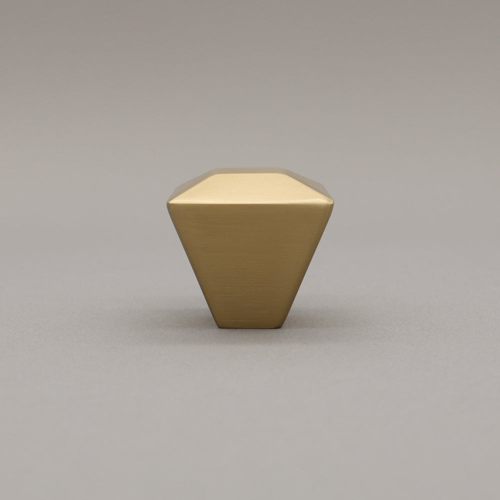 satin brass gold geometric diamond knob on a gray background standing