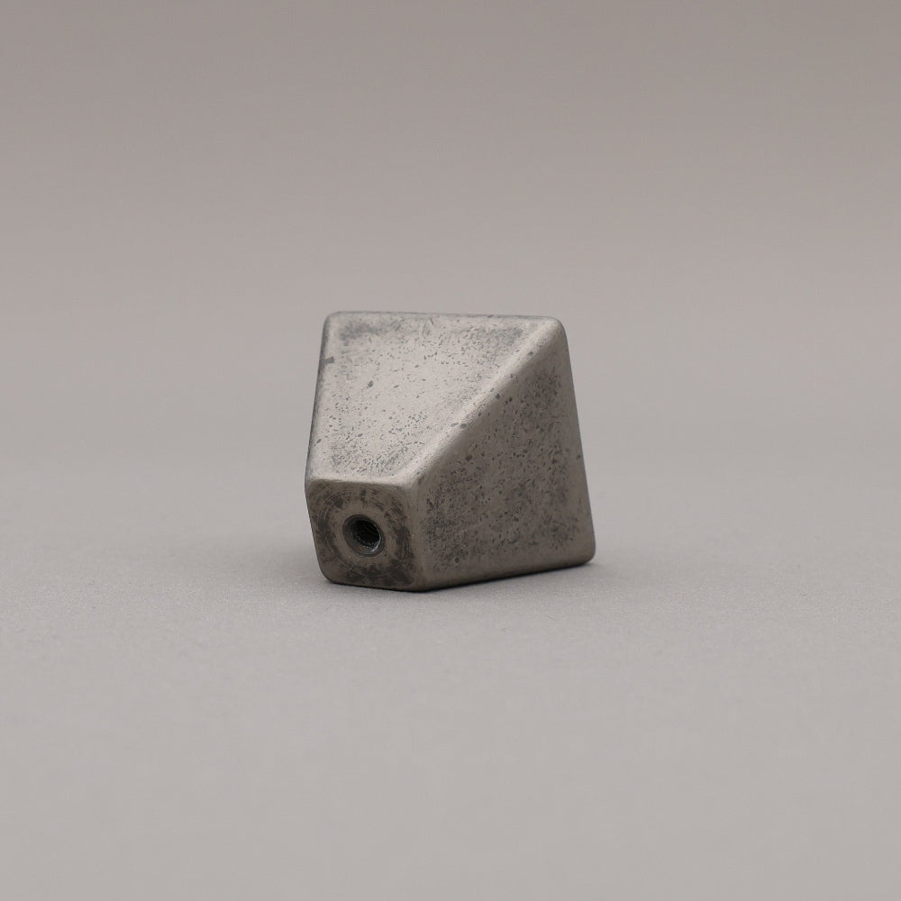 weathered distressed nickel geometric diamond knob on gray background rear view