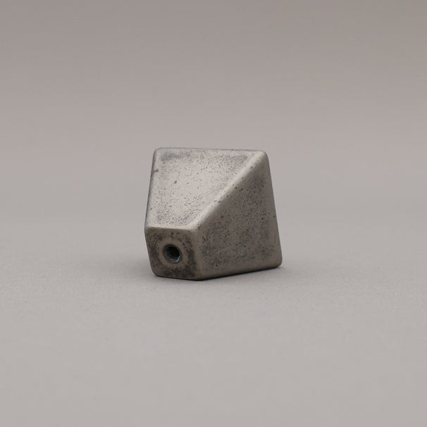 weathered distressed nickel geometric diamond knob on gray background rear view