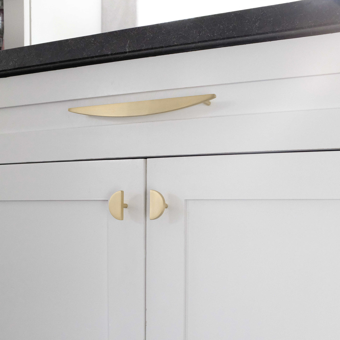 Gold Half Moon Cabinet Pulls on White Kitchen Drawer and Cabinets.