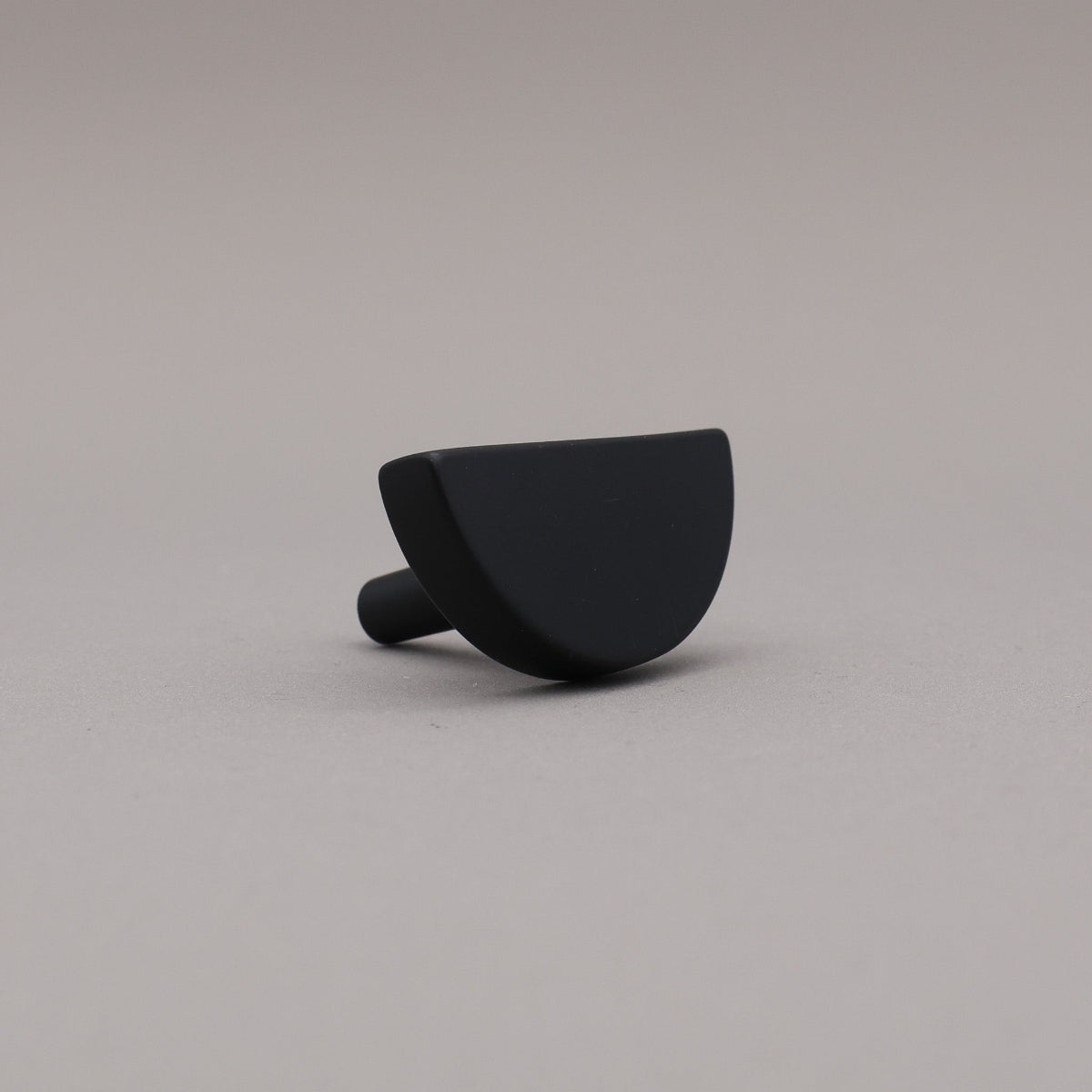 matte black half moon knob on gray background
