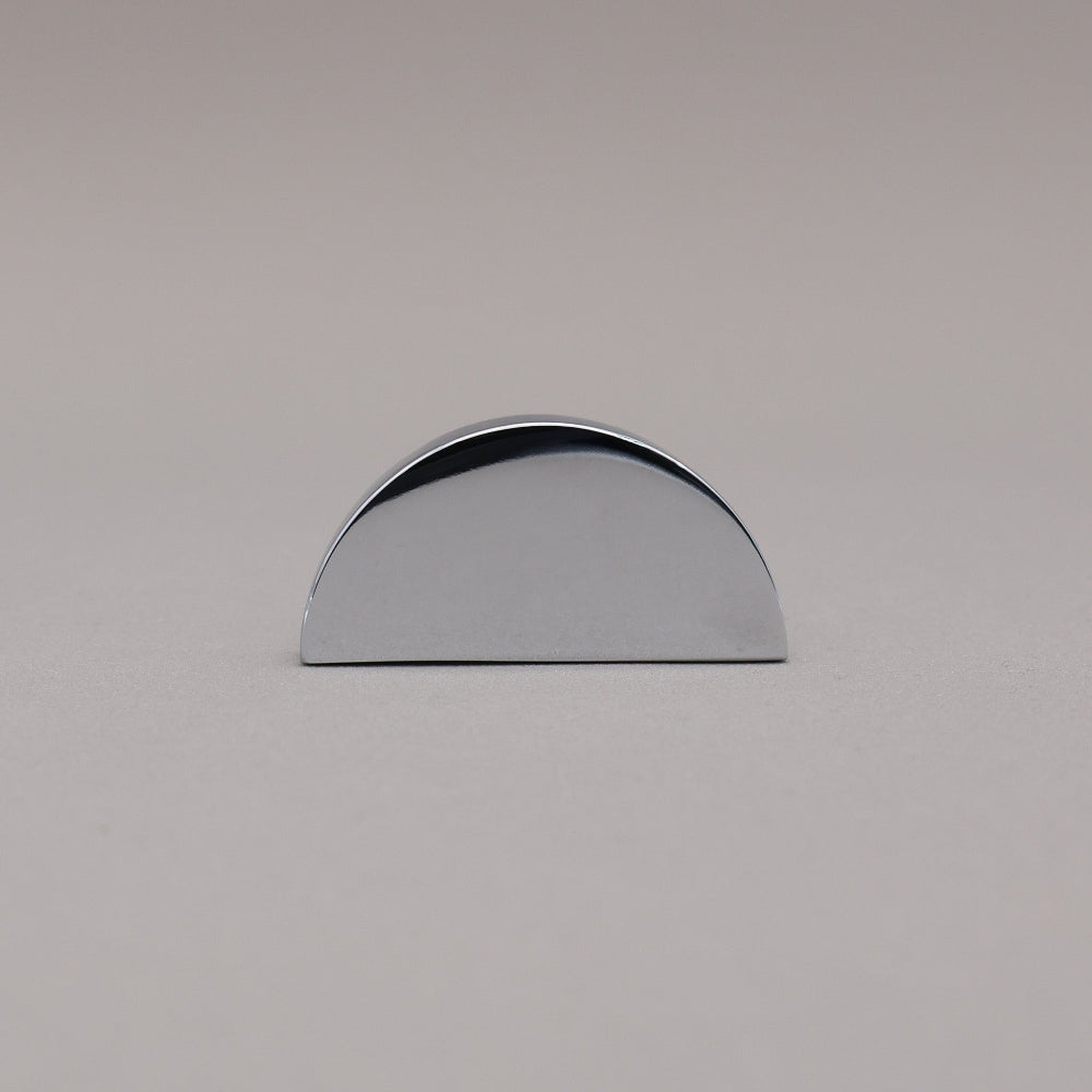 half moon polished chrome knob on gray background