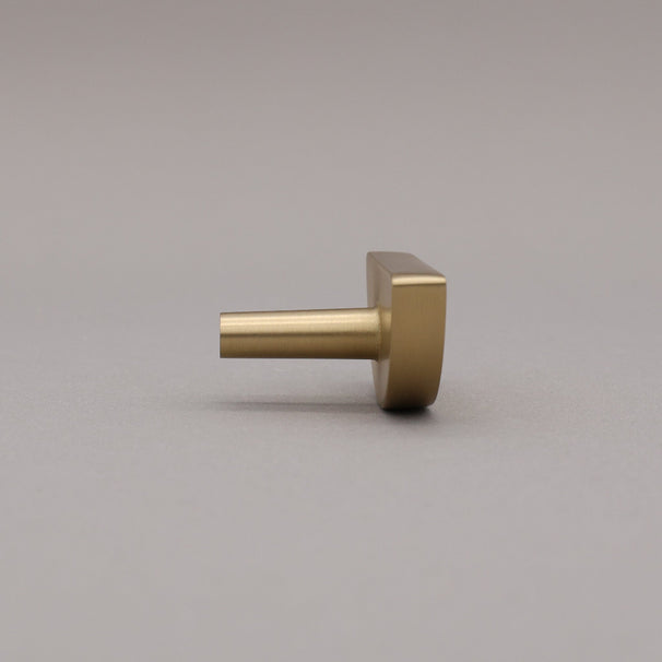 satin brass gold half-circle half moon cabinet knob on gray background