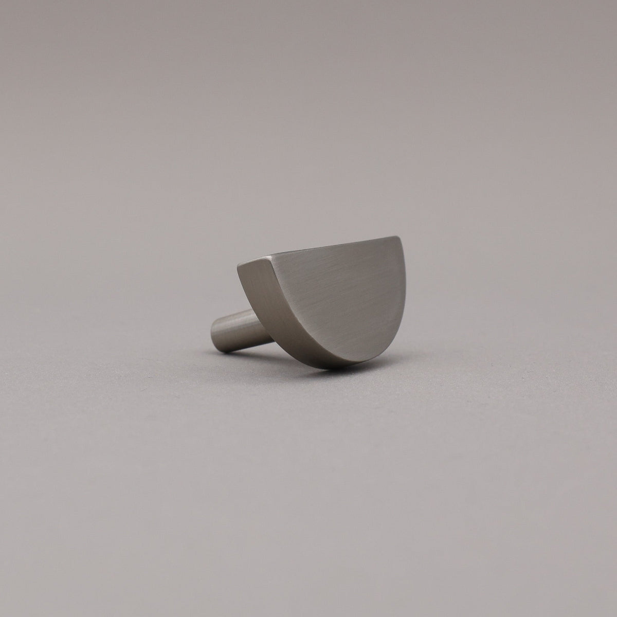 satin nickel silver half moon knob on gray background