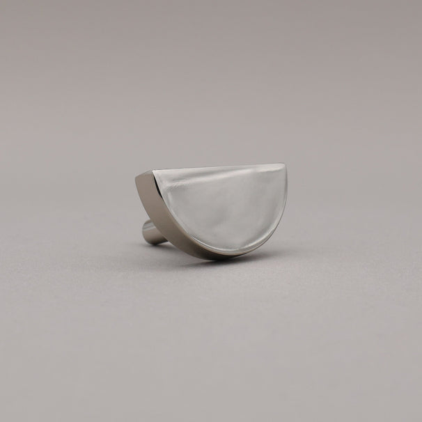 polished nickel silver half moon knob on gray background