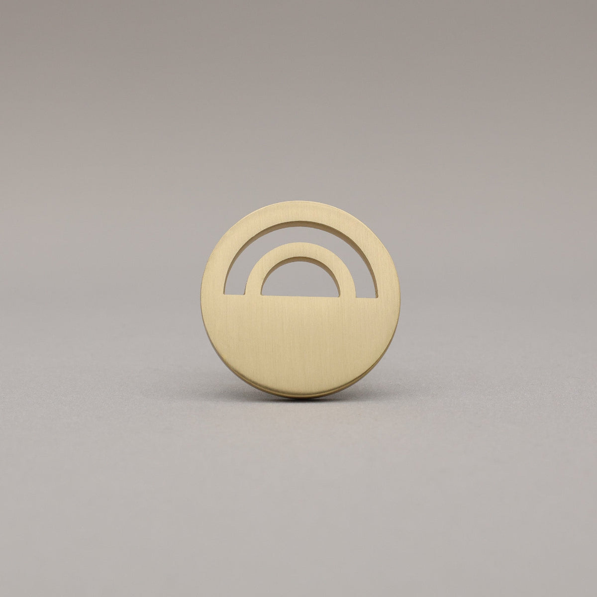 Horizon Satin Brass Knobs on grey background.