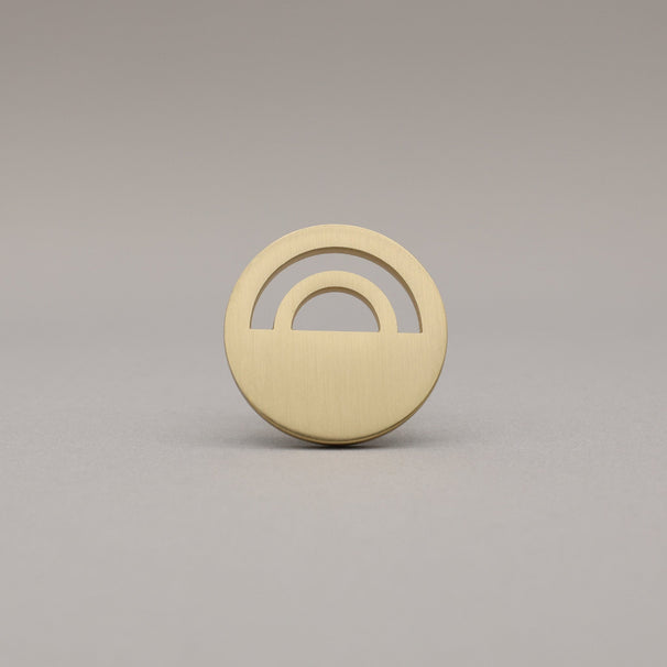 Horizon Satin Brass Knobs on grey background.