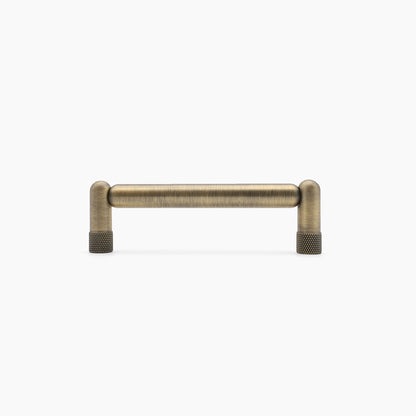 Aged brass cabinet handle on a white background,