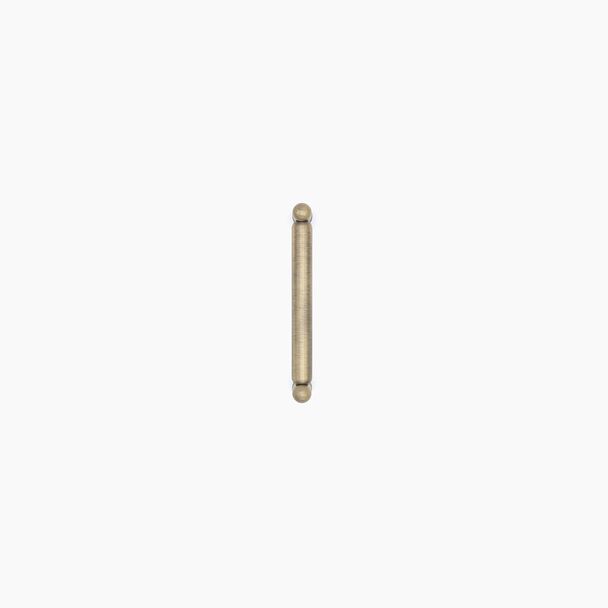Aged brass colored cylindrical pull on a white background.