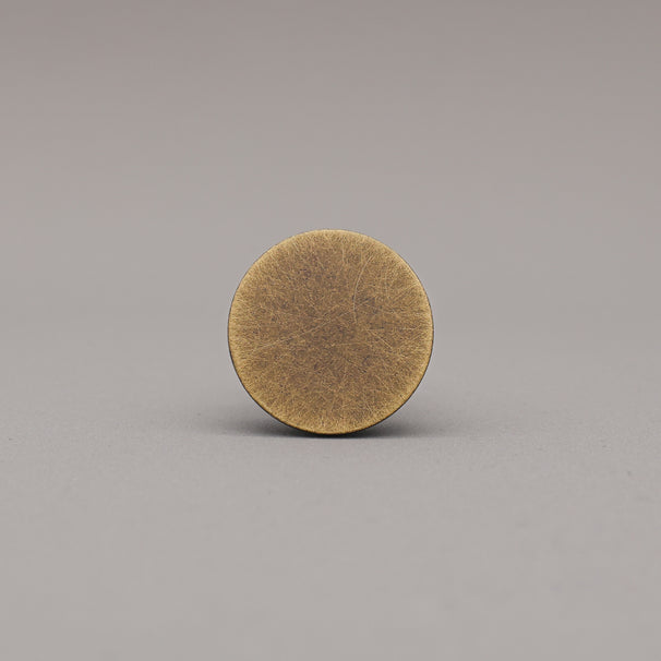 Round brass object on a gray background
