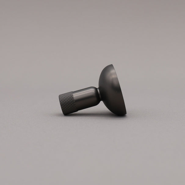 Black metal knob on a gray background