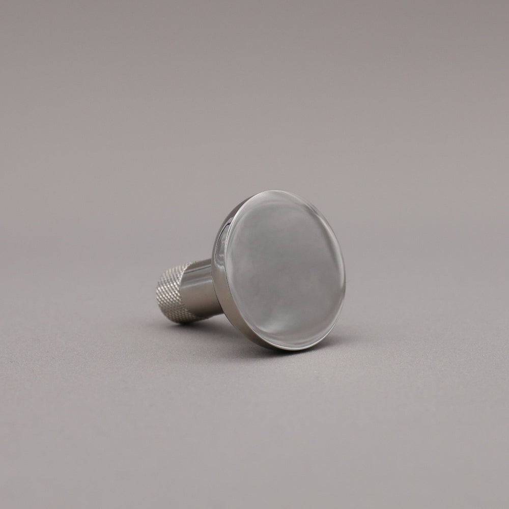Polished nickel finished knurled cabinet knob on a gray background