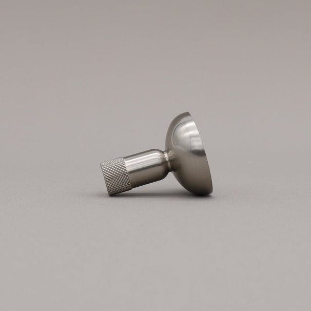 Satin Nickel knurled knob on a gray background.