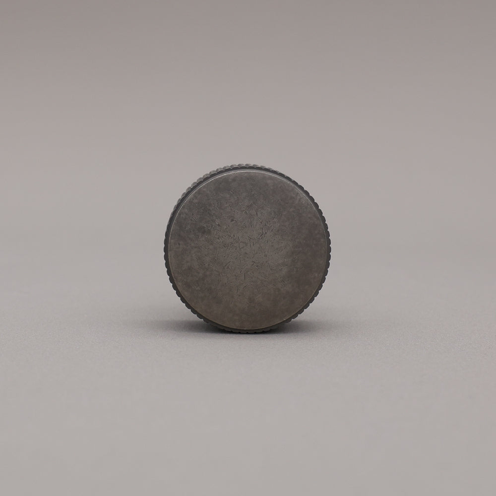 weathered nickel silver textured ribbed knob with fluting detail on a gray background