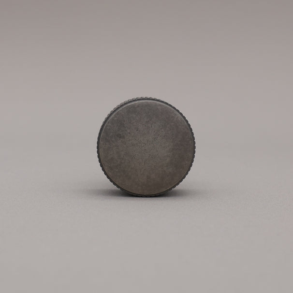 weathered nickel silver textured ribbed knob with fluting detail on a gray background