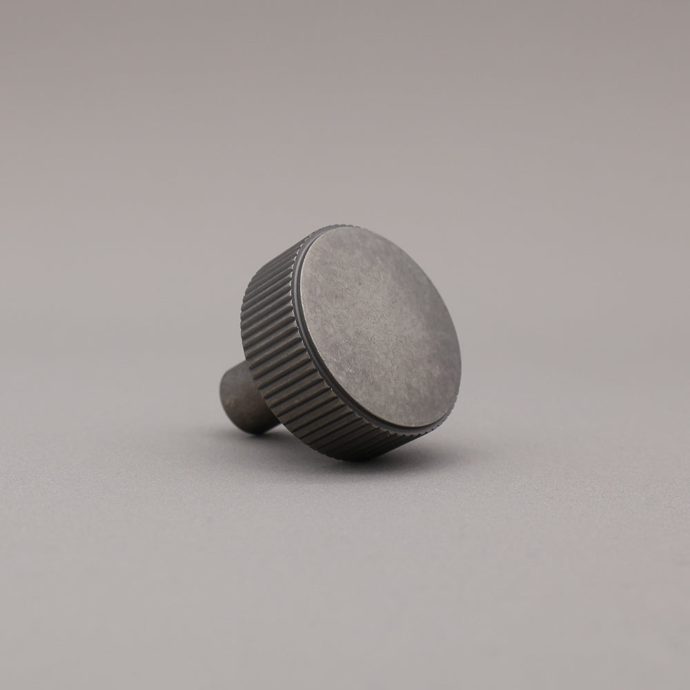 weathered nickel silver textured ribbed knob with fluting detail on a gray background