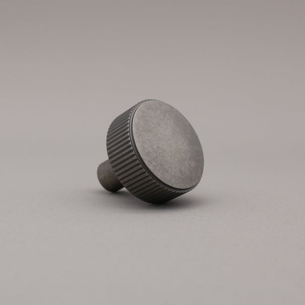 weathered nickel silver textured ribbed knob with fluting detail on a gray background