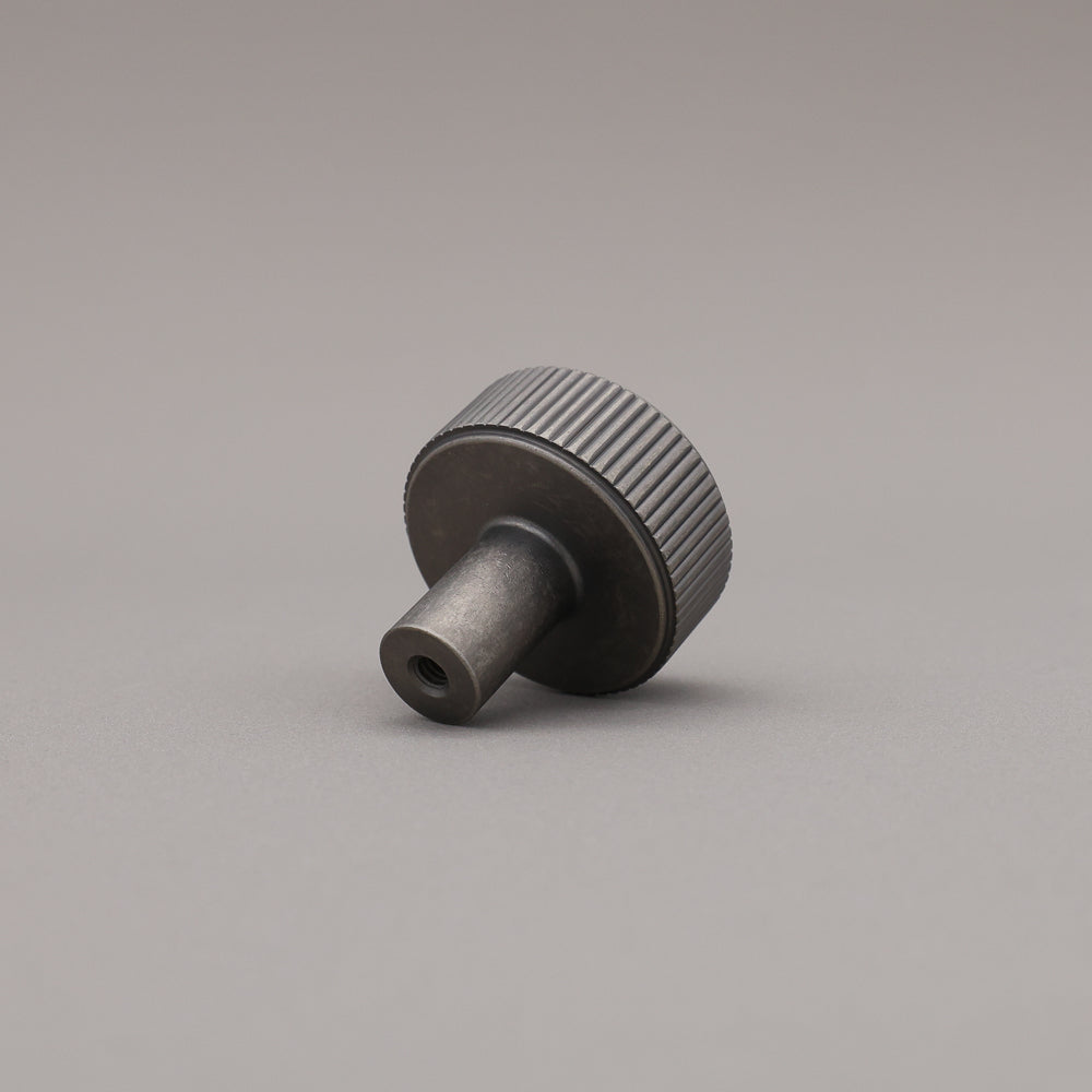weathered nickel silver textured ribbed knob with fluting detail on a gray background