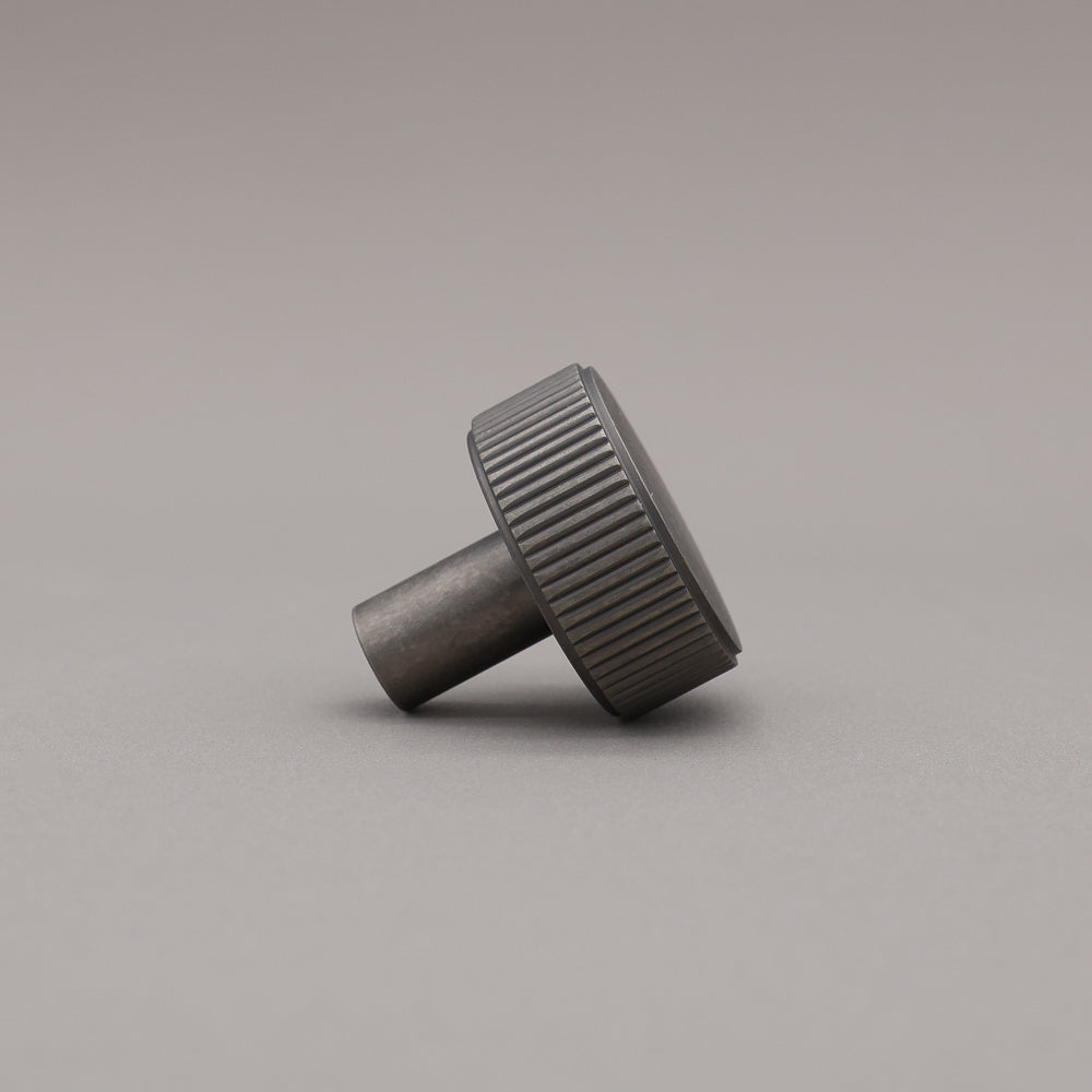 weathered nickel silver textured ribbed knob with fluting detail on a gray background