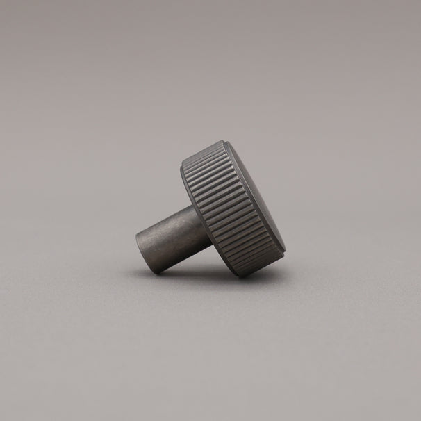 weathered nickel silver textured ribbed knob with fluting detail on a gray background