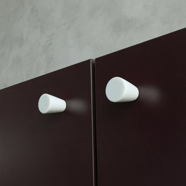 Marble knobs finished in a Carrara Marble on Burgundy cabinets.