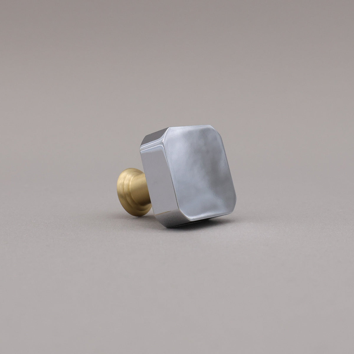 polished chrome and satin brass gold two tone square mod knob on gray background