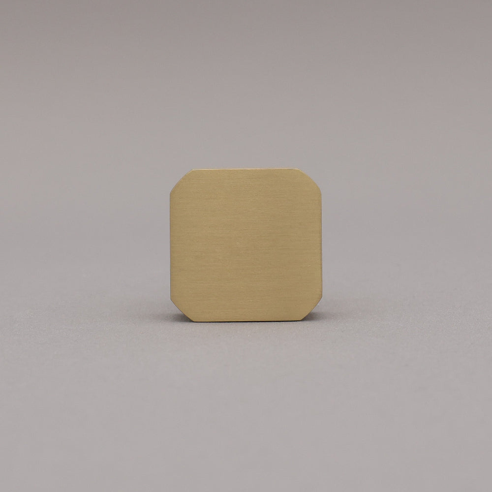 Satin brass gold square knob on gray background