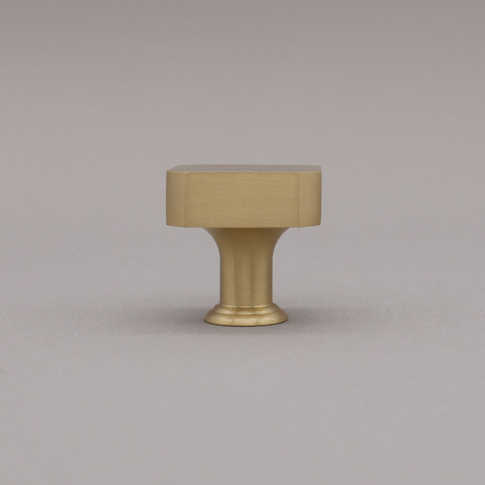 Satin brass gold square knob on gray background